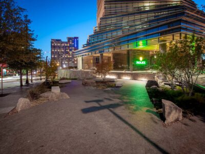 Rolex Building plaza at night with Dallas cityscape