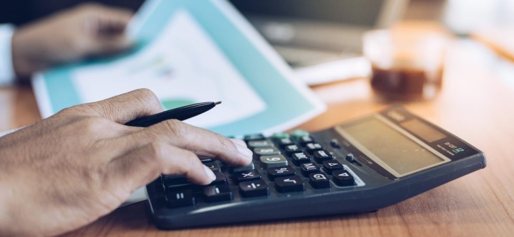 Business man holding pen and using calculator to analyze right of way data